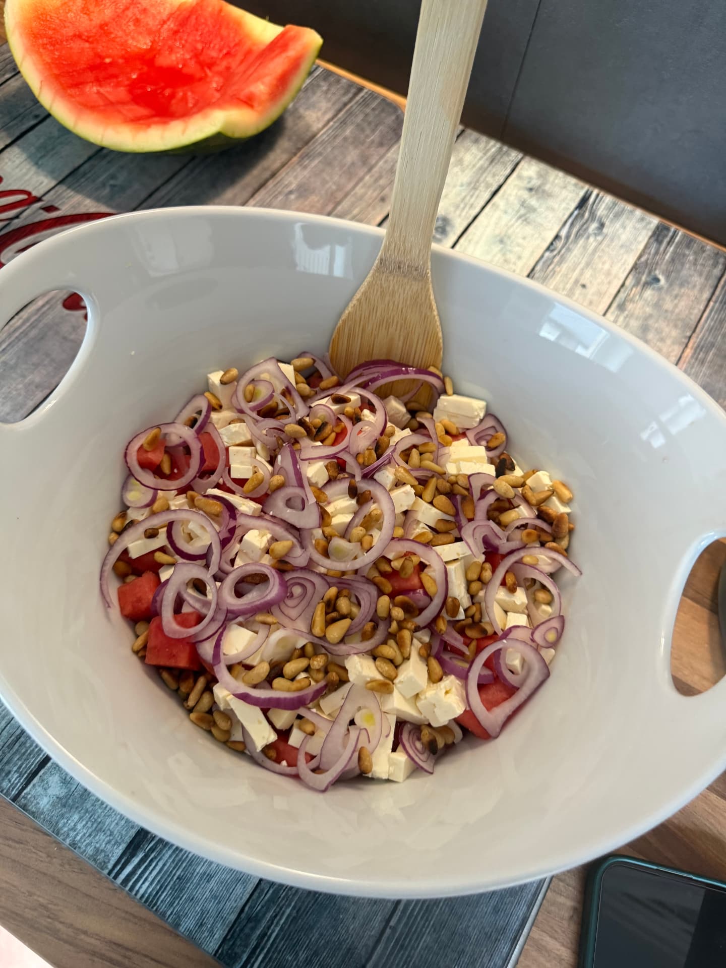 Melonensalat mit Schafskäse, roten Zwiebeln und Pinienkernen in einer Schüssel